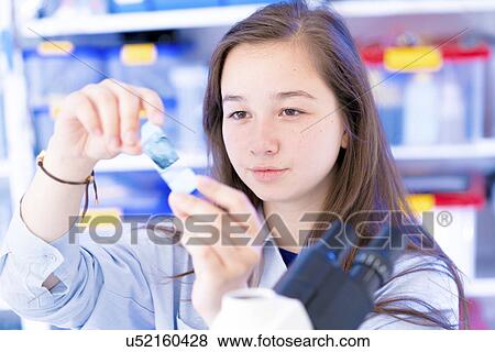 Stock Photo - Girl examining microscope slide. Fotosearch