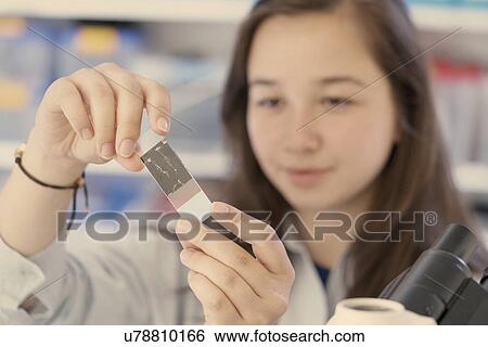 Stock Photograph - Girl examining microscope slide. Fotosearch
