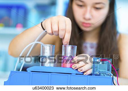 Stock Image - Girl experimenting with fuel cell. Fotosearch