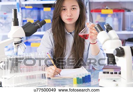 Girl holding chemical flask View Large Photo Image Stock Photo - Girl holding chemical flask. Fotosearch