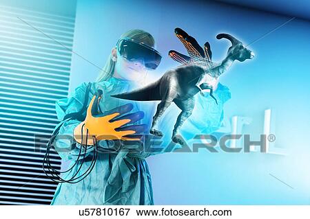 Stock Photo - Girl in virtual reality headset interacting with digital floating dinosaur. Fotosearch