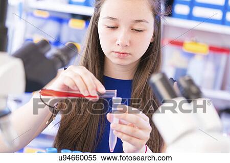 Stock Photography - Girl pouring chemical into test tube. Fotosearch