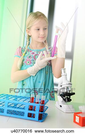 Stock Photograph - Girl pretending to be scientist examining test tube. Fotosearch
