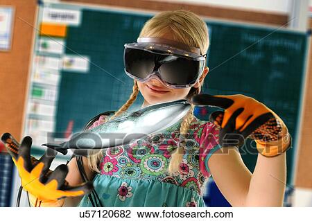 Stock Image - Girl pretending to be teacher wearing virtual reality headset and gloves to show whale. Fotosearch