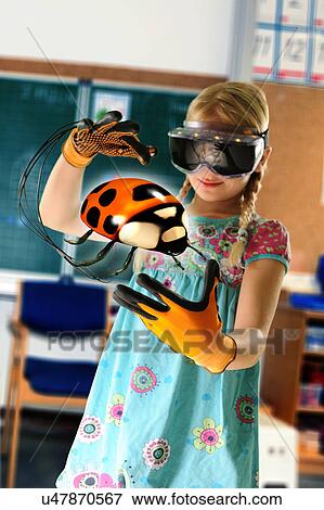 Stock Photo - Girl pretending to be teacher wearing virtual reality headset and gloves to show ladybird. Fotosearch