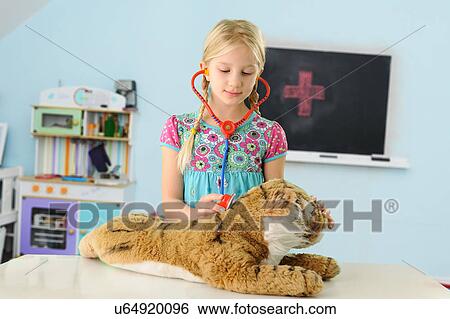 Girl pretending to be vet examining toy tiger using stethoscope View Large Photo Image Stock Photograph - Girl pretending to be vet examining toy tiger using stethoscope. Fotosearch