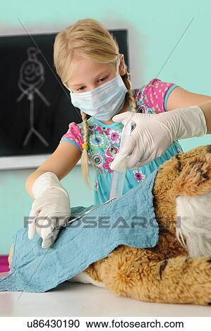 Girl pretending to be vet giving toy tiger syringe injection during operation View Large Photo Image Stock Image - Girl pretending to be vet giving toy tiger syringe injection during operation. Fotosearch