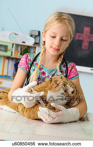 Girl pretending to be vet giving toy tiger syringe injection View Large Photo Image Stock Photograph - Girl pretending to be vet giving toy tiger syringe injection. Fotosearch