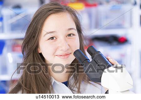 Stock Image - Girl using microscope, portrait. Fotosearch