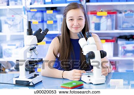 Stock Image - Girl using microscope. Fotosearch