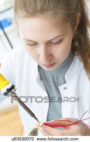Stock Image - Girl using soldering iron. Fotosearch