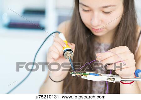 Stock Image - Girl using soldering iron. Fotosearch