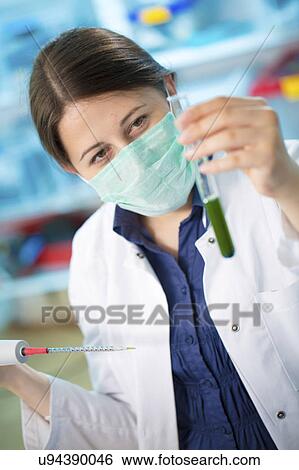 Stock Photograph - Girl wearing mask holding test tube. Fotosearch