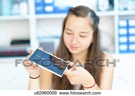 Stock Photo - Girl working on solar cell in classroom. Fotosearch