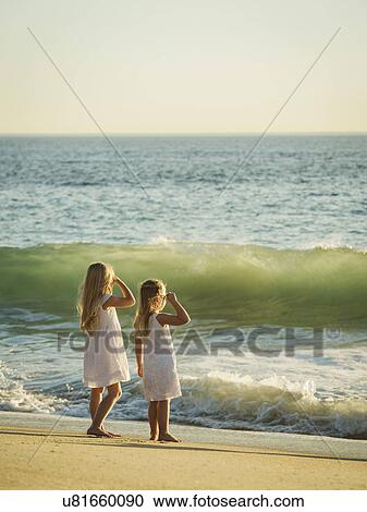 Girls (4-5, 6-7) standing on beach and looking at sea View Large Photo Image Stock Image - Girls (4-5, 6-7) standing on beach and looking at sea. Fotosearch