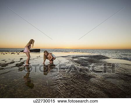 Girls (6-7, 8-9) playing on beach View Large Photo Image Stock Photography - Girls (6-7, 8-9) playing on beach. Fotosearch