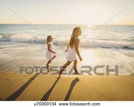 Girls (6-7, 8-9) running on beach View Large Photo Image Picture - Girls (6-7, 8-9) running on beach. Fotosearch
