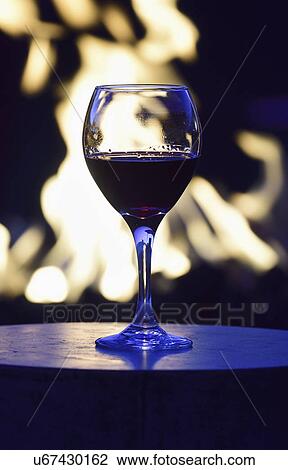 Glass of red wine against fire pit at night View Large Photo Image Stock Image - Glass of red wine against fire pit at night. Fotosearch
