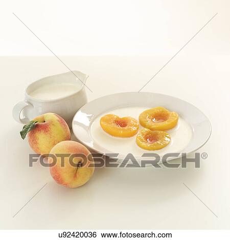 Stock Photograph - Halved peaches in bowl of cream. Fotosearch