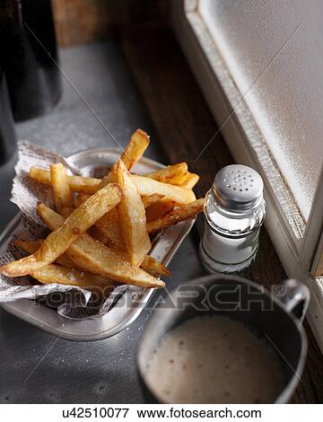 Stock Photo - Hand cut chips and salt shaker. Fotosearch