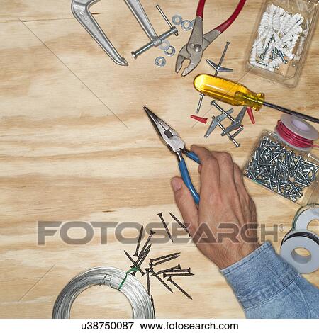 Hand of man holding pliers in workshop View Large Photo Image Stock Photo - Hand of man holding pliers in workshop. Fotosearch