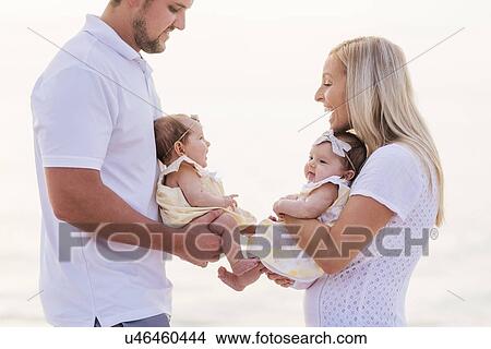 Picture - Happy couple with twins (2-5 months). Fotosearch