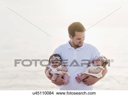Picture - Happy father holding babies (2-5 months). Fotosearch