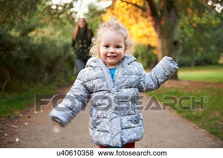 Happy female toddler running in autumn park View Large Photo Image Stock Photo - Happy female toddler running in autumn park. Fotosearch