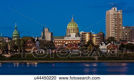 Stock Image - HARRISBURG, PENNSYLVANIA, City skyline and State Capitol shot at dusk from Susquehanna River. Fotosearch