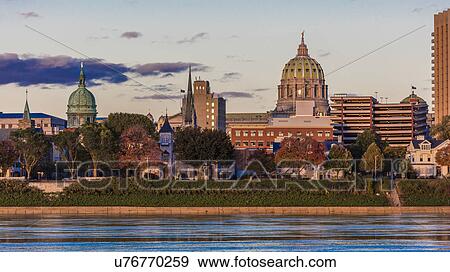 Stock Photo - HARRISBURG, PENNSYLVANIA, City skyline and State Capitol shot at dusk from Susquehanna River. Fotosearch