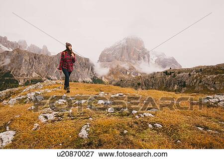 Stock Photo - Hiker walking, Mount Lagazuoi in background, Dolomite Alps, South Tyrol, Italy. Fotosearch