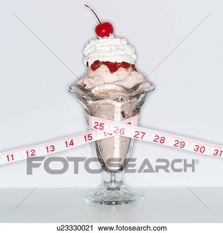 Stock Image - Ice cream sundae wrapped with tape measure. Fotosearch