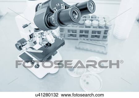 Stock Image - Laboratory microscope and petri dishes. Fotosearch