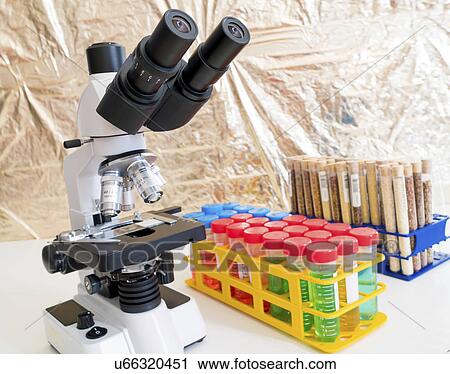 Stock Image - Laboratory microscope and test tubes. Fotosearch