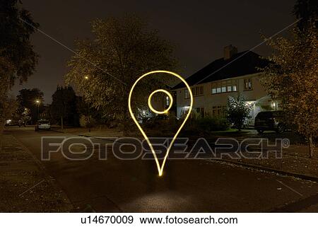 Stock Photo - Light painted drop pin symbol floating on suburban street at night. Fotosearch