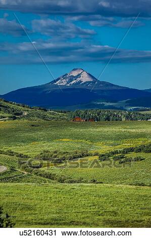 Stock Image - Log Cabin with Mountains and green trees - San Juan Mountains, Colorado, USA. Fotosearch