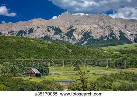 Stock Photography - Log Cabin with Mountains and green trees - San Juan Mountains, Colorado, USA. Fotosearch