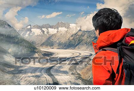 Stock Photo - Lone male climber looking out over Aletsch Glacier, Canton Wallis, Switzerland. Fotosearch
