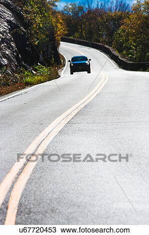 Stock Image - Lonely car on mountain road. Fotosearch