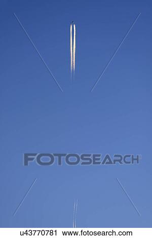 Stock Image - Low angle view of commercial airplane flying against blue sky. Fotosearch