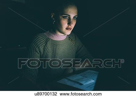 Low key portrait of young woman staring at laptop View Large Photo Image Stock Image - Low key portrait of young woman staring at laptop. Fotosearch