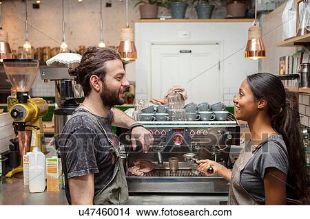 Male and female baristas talking by cafe coffee machine View Large Photo Image Picture - Male and female baristas talking by cafe coffee machine. Fotosearch
