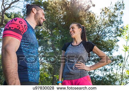 Stock Photo - Male and female runners chatting in park, Split, Dalmatia, Croatia. Fotosearch