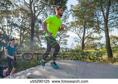 Stock Photography - Male and female runners running up park stairway, Split, Dalmatia, Croatia. Fotosearch