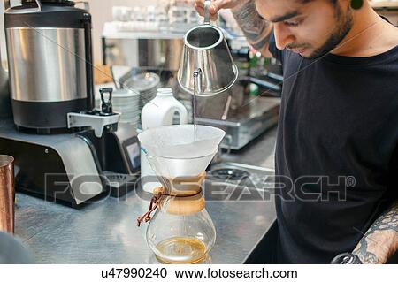 Stock Image - Male barista preparing filter coffee in cafe. Fotosearch