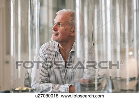 Stock Photo - Man daydreaming at home. Fotosearch