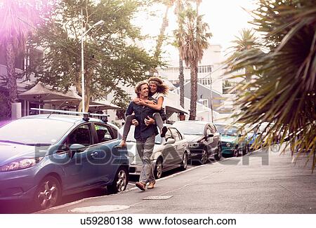 Man giving girlfriend piggyback down street, Cape Town, South Africa View Large Photo Image Stock Photo - Man giving girlfriend piggyback down street, Cape Town, South Africa. Fotosearch