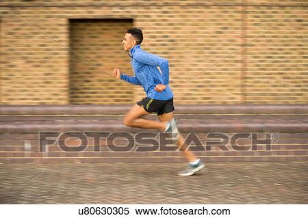 Man running past brick wall, Wapping, London, UK View Large Photo Image Stock Photography - Man running past brick wall, Wapping, London, UK. Fotosearch
