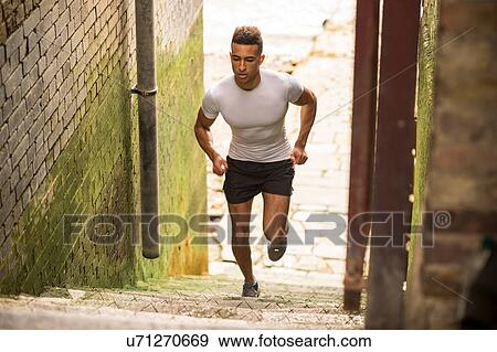 Stock Photo - Man running up stairs in old building. Fotosearch