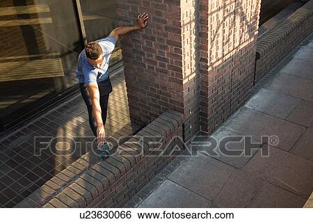 Stock Photograph - Man stretching beside column. Fotosearch
